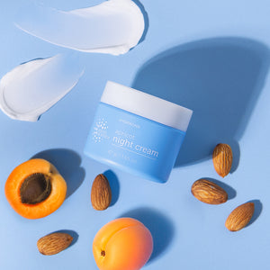 Blue jar of night cream with apricots and almonds on a blue background