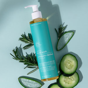 Facial wash bottle with aloe vera leaves and cucumber slices on a light blue background
