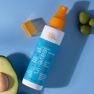 Leave-in conditioner spray bottle with avocado and olive on a blue background